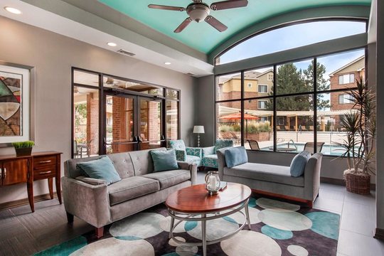 Cierra Crest Apartments - Clubhouse Lounge Area with Ceiling Fan and Swimming Pool Overlooking